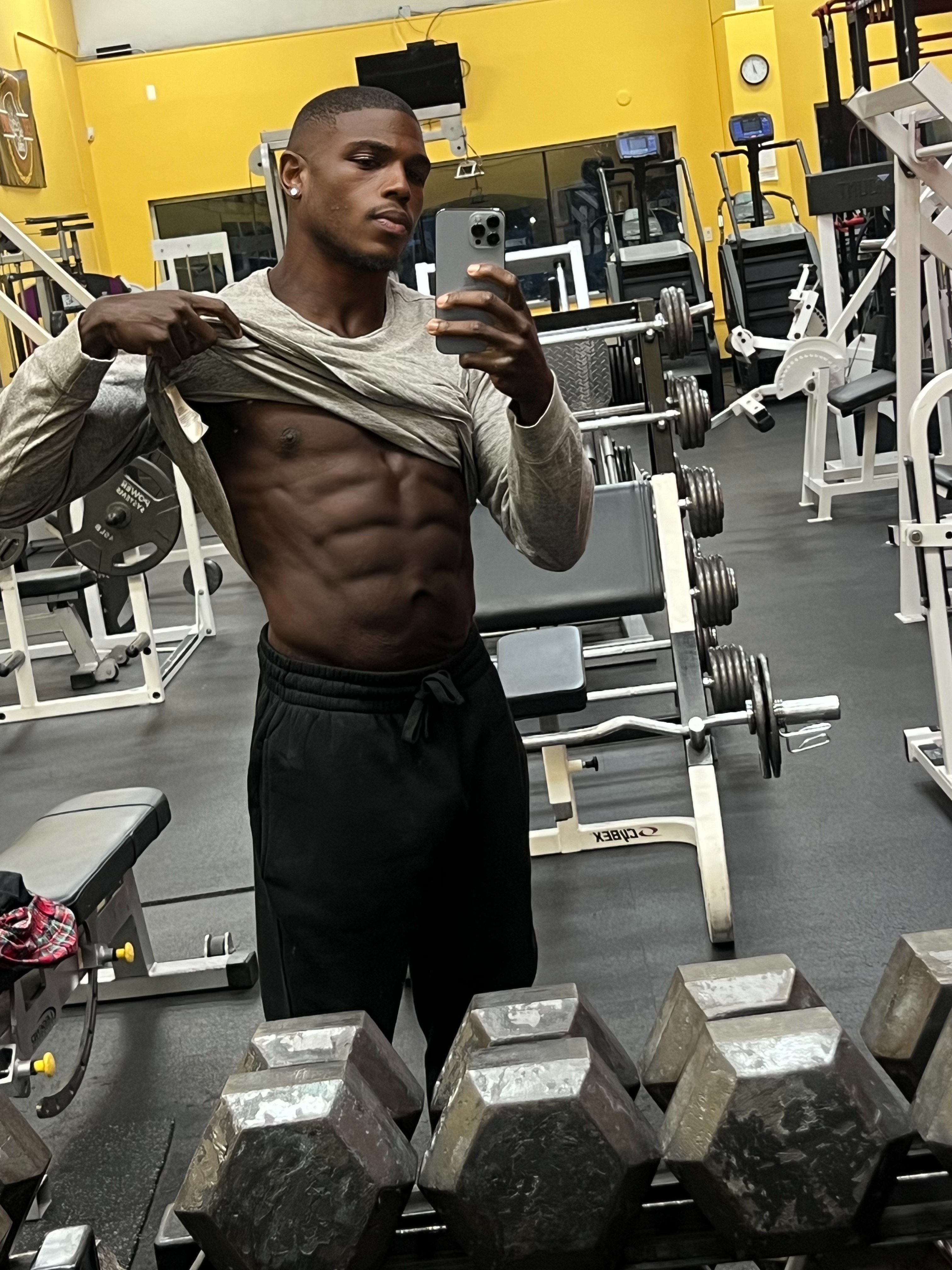 Andre after transformation, gym mirror selfie showing abs