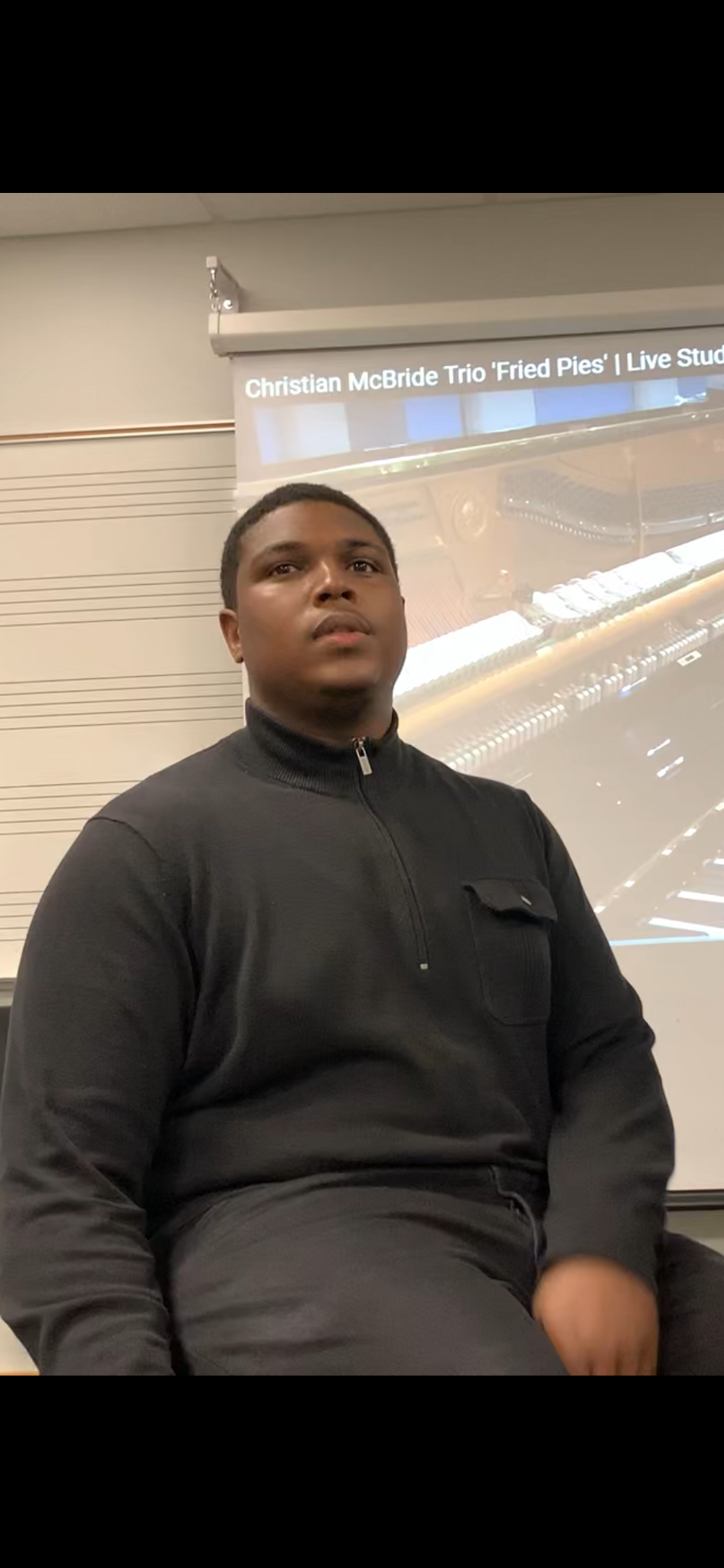 Andre in black shirt teaching with whiteboard and projector